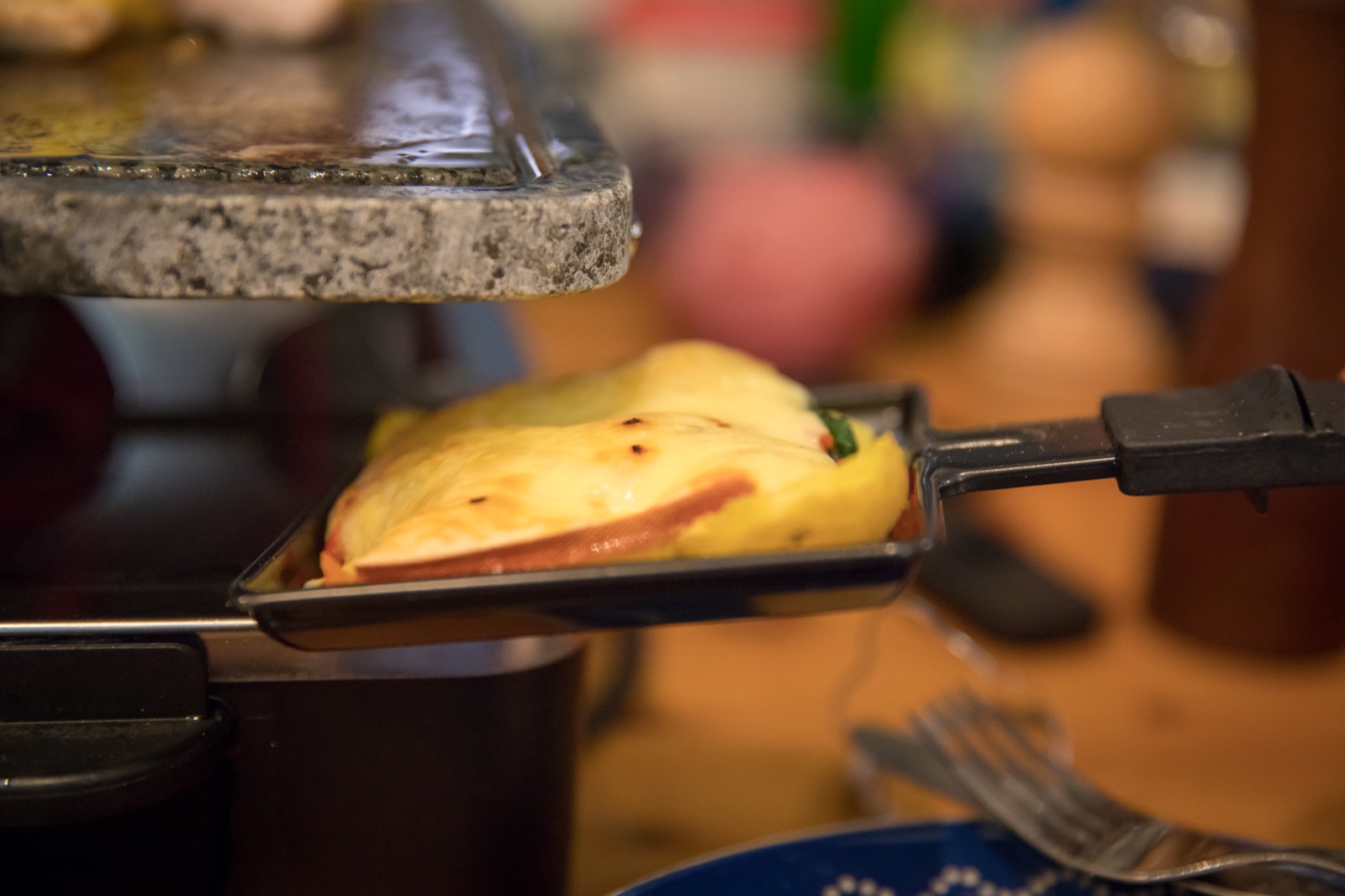 raclette grills running at a big party with guests melting cheese