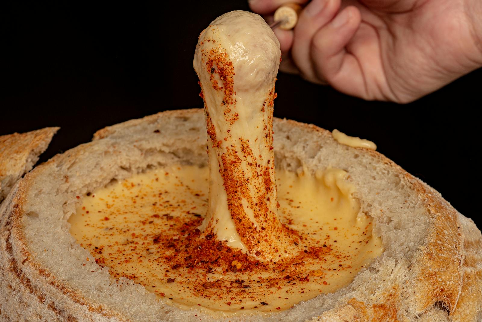 Melted raclette cheese over seafood in coupelles on a convivial dinner table