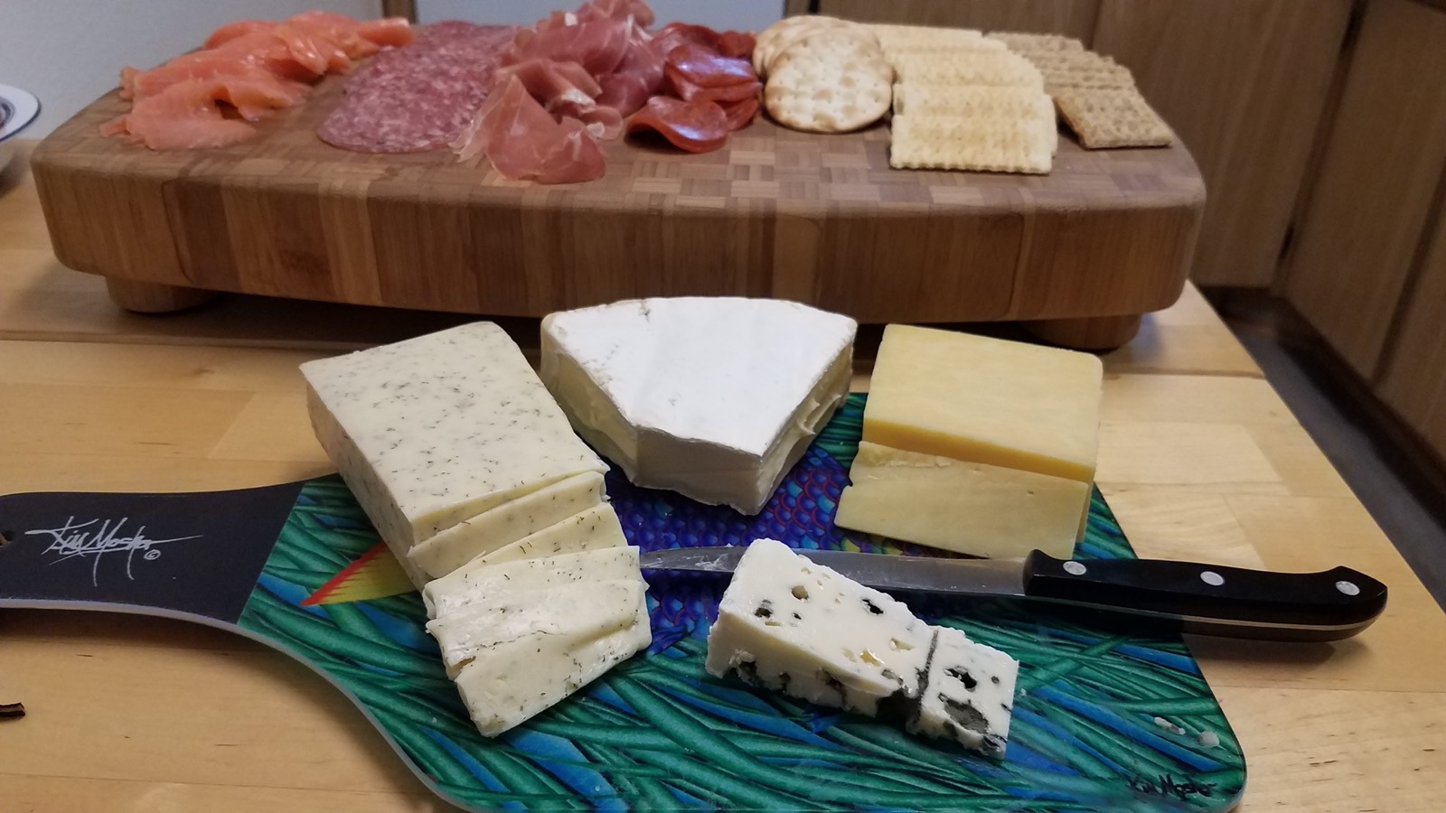 Speck und Bresaola in Scheiben auf Holzbrett für Raclette — beste Fleisch-Kombinationen für Raclette