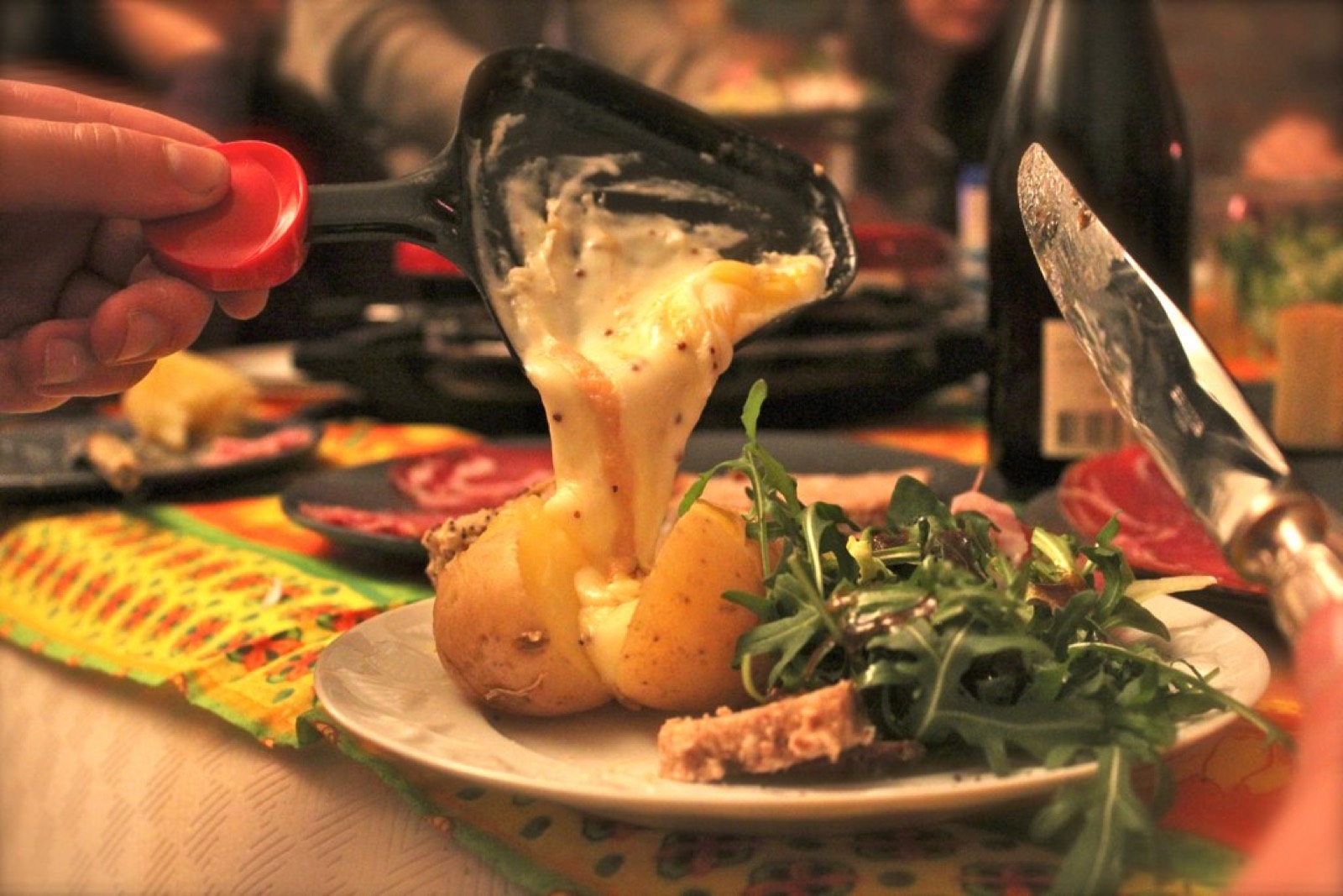 vegetarian raclette table spread with potatoes pickles and fruits